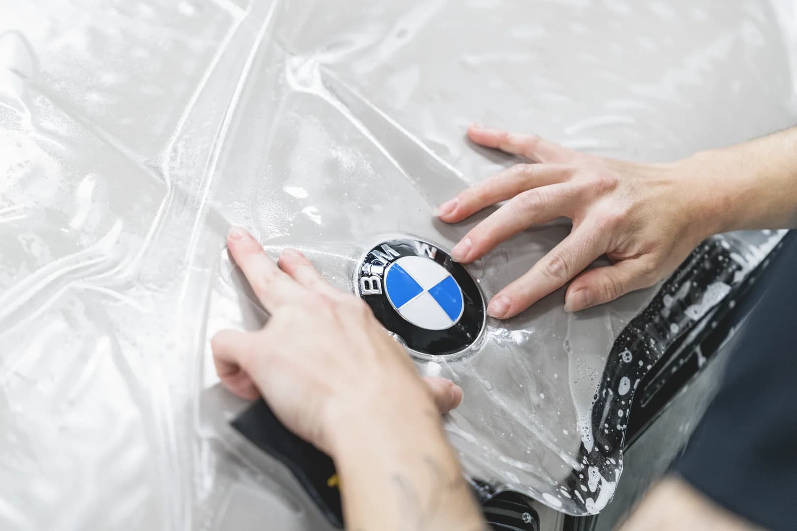 Paint protection film being fitted around a BMW's headlight
